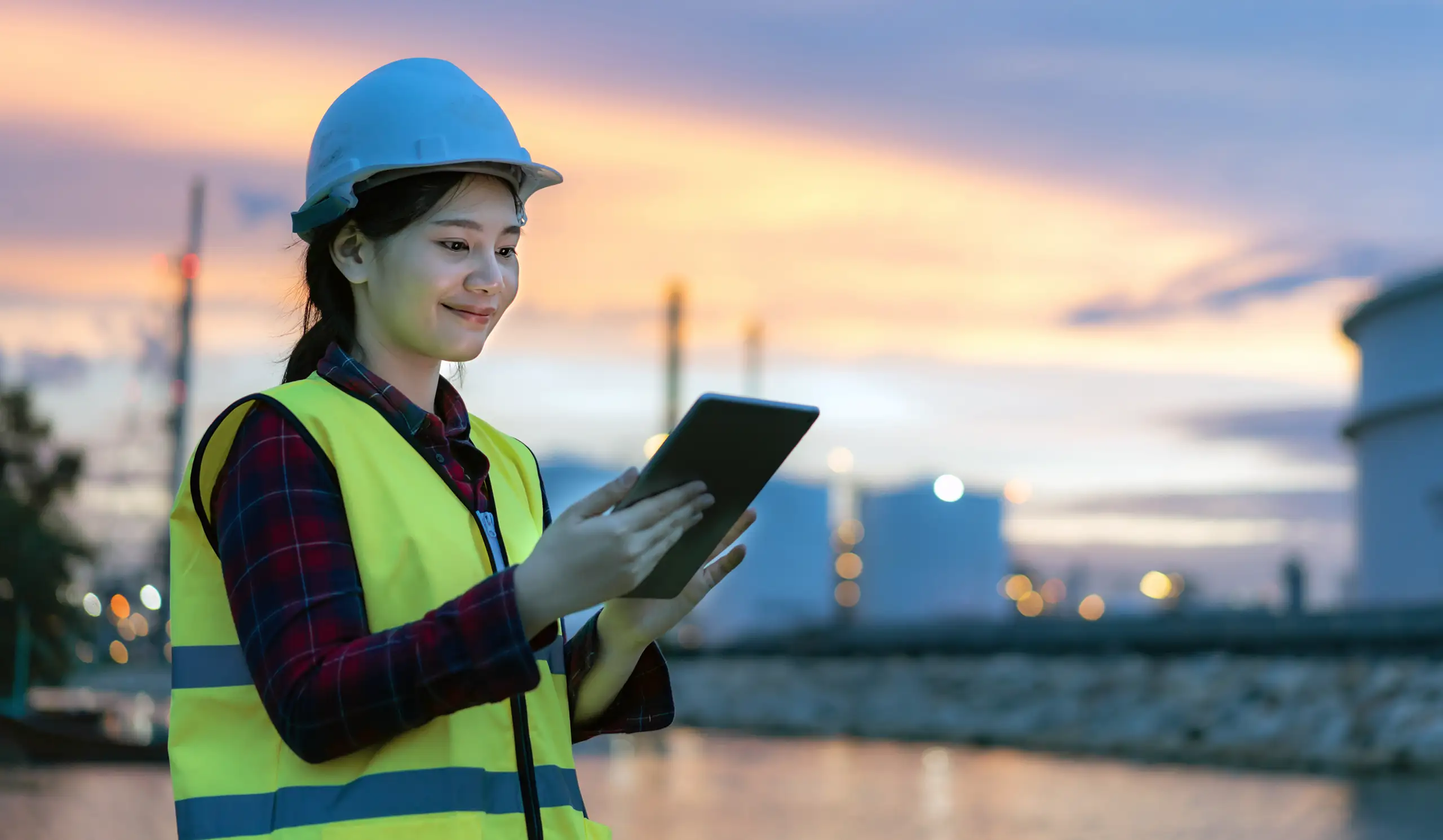 woman engineer looking at maintenance tablet Predictive maintenance software & analyzer data collection - AIM